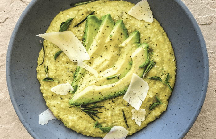 Avocado Parmesan Grits in a large bowl with shaved parmesan