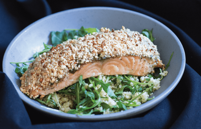 Cashew Crusted Salmon with Pesto and Honey over arugula