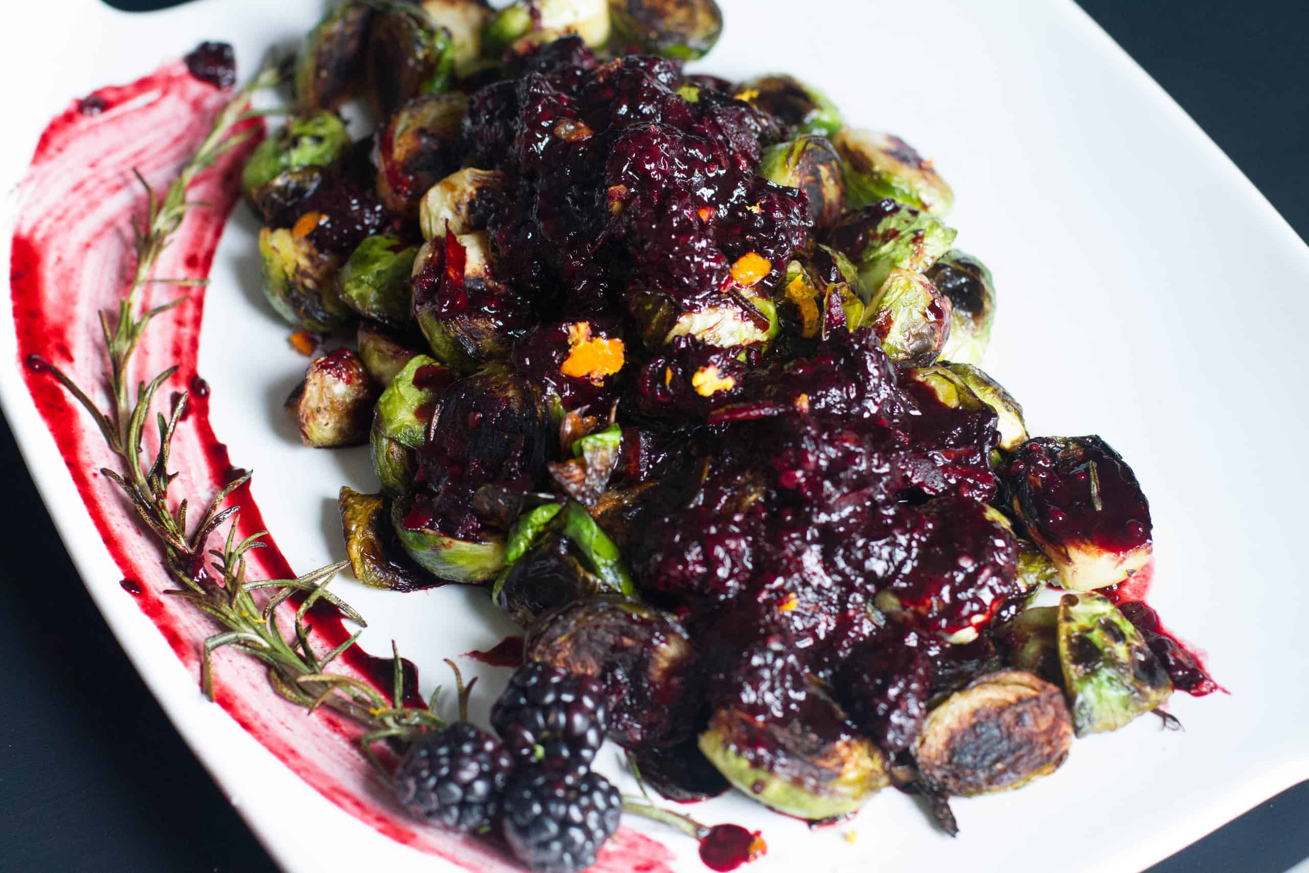 close up overhead shot of crispy brussels sprouts blackberry reduction