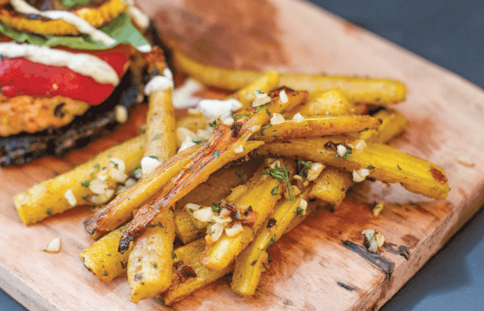 close up of Garlic & Sea Salt Carrot Fries on wooden chopping board