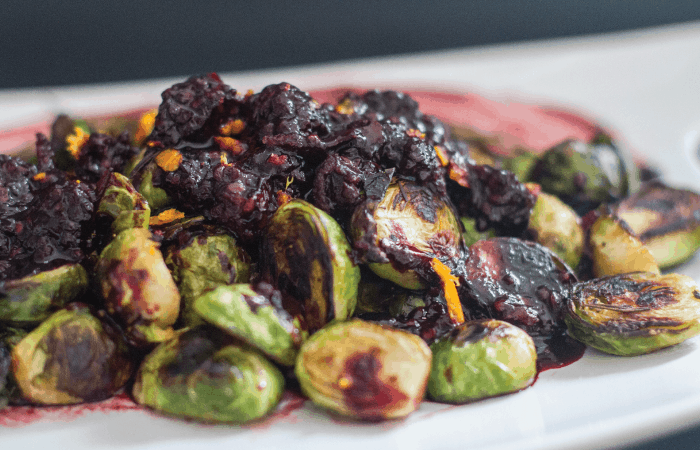 close up of crispy brussels sprouts blackberry reduction