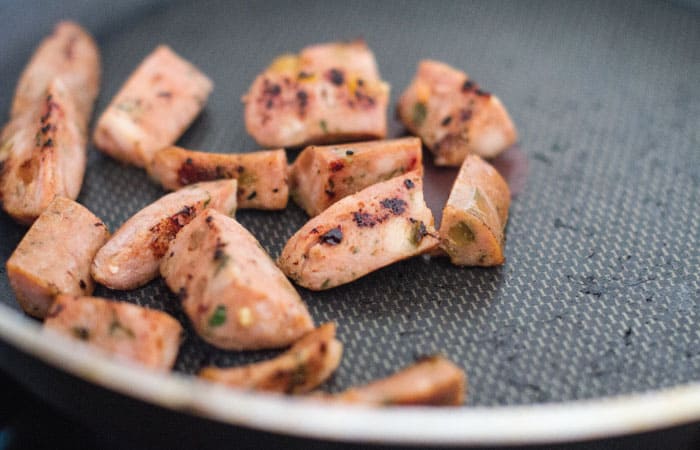 Chopped chicken sausage cooking in pan