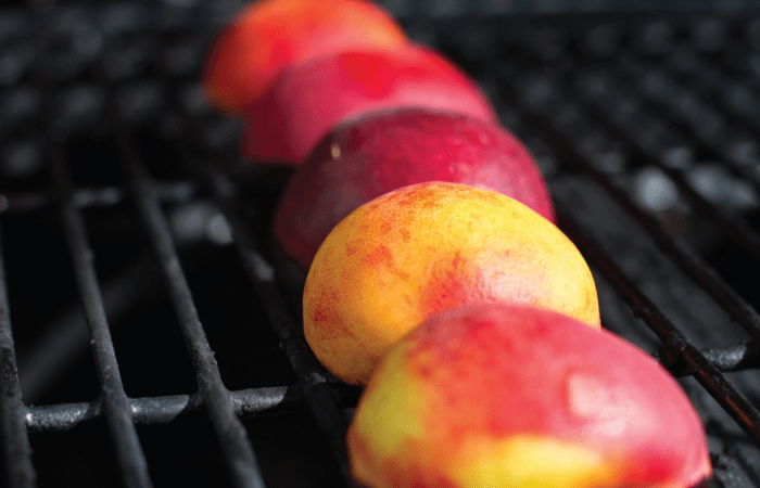 sliced peaches laying on the grill