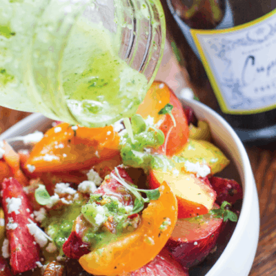 Pouring Jalapeno & Prosecco Vinaigrette over Summer Stone Fruit Salad