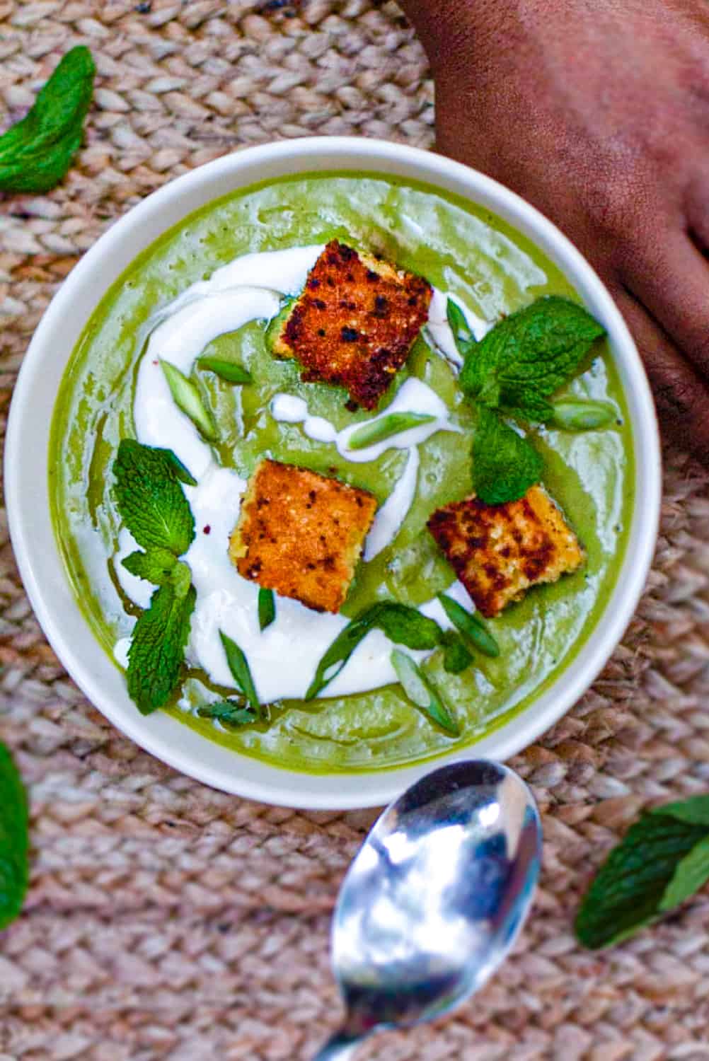 Overhead shot of bowl of pea & mint soup with cornbread croutons