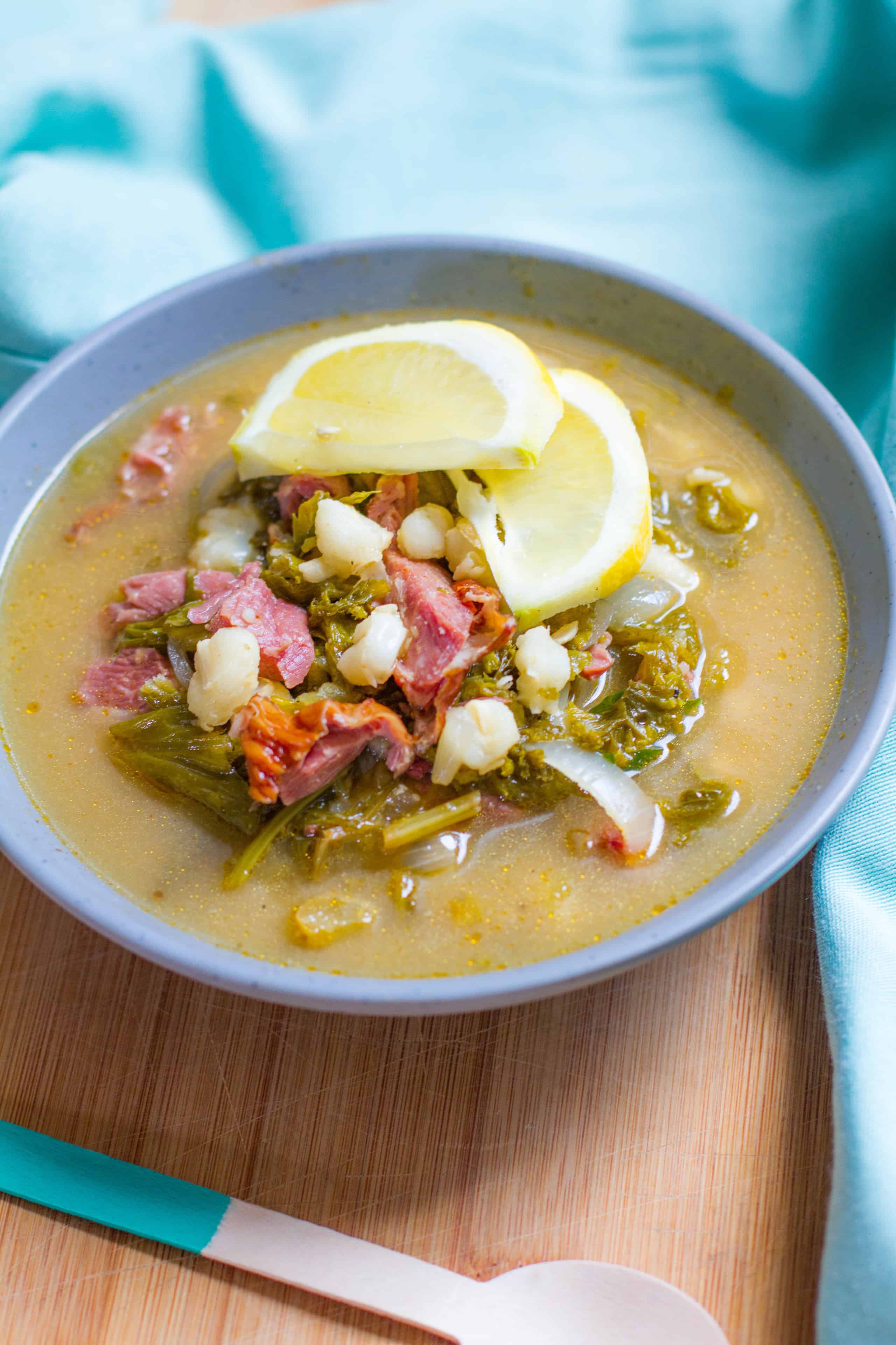 Close up bowl of Lemony Southern Style Posole garnished with lemon slices.