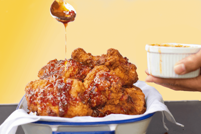 Pepper Jelly Molasses being drizzled on Crispy Fried Chicken