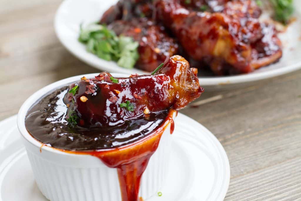 Spicy coca-cola wings on in a bowl of extra sauce