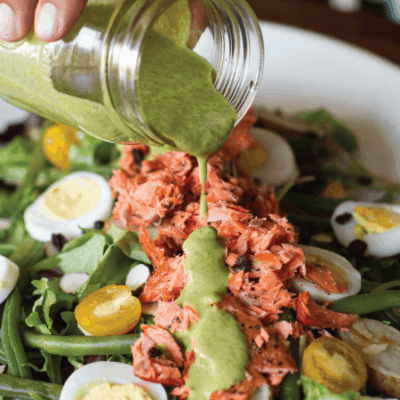 creamy green dressing poured onto salad