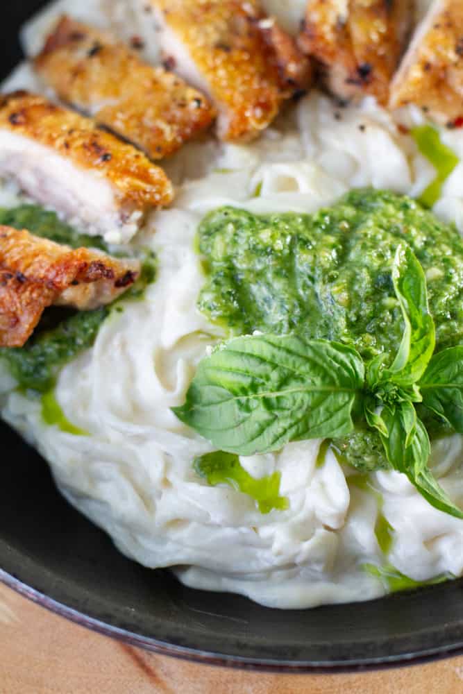 Keto Fettuccine Alfredo topped with Homemade Pesto Sauce and crispy chicken