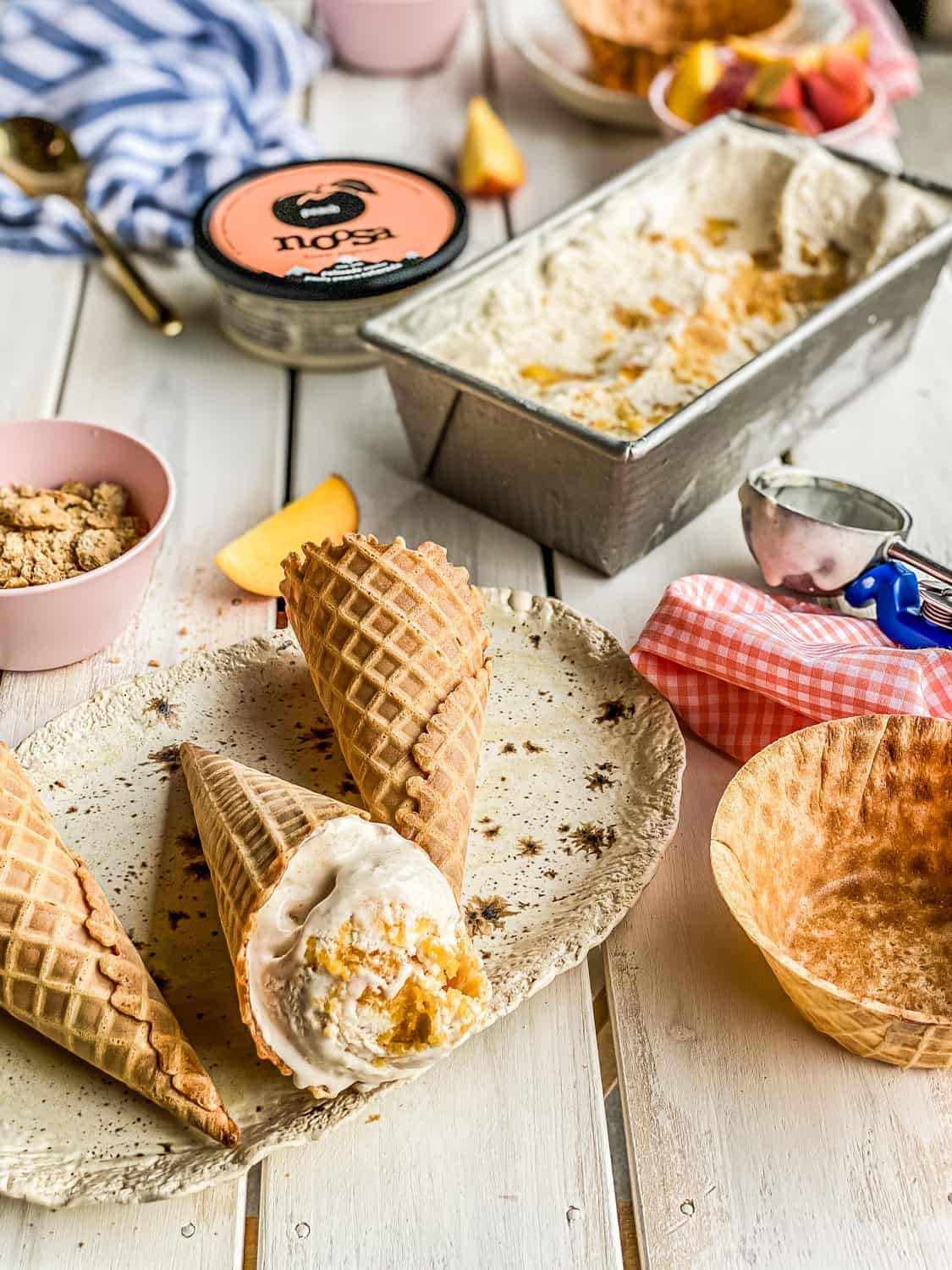 peach frozen yogurt in a waffle cone on a picnic table