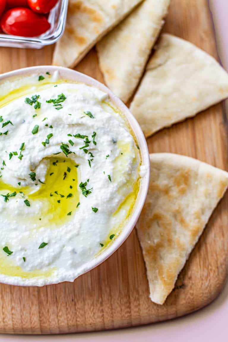 whipped feta in bowl with pita bread on the side