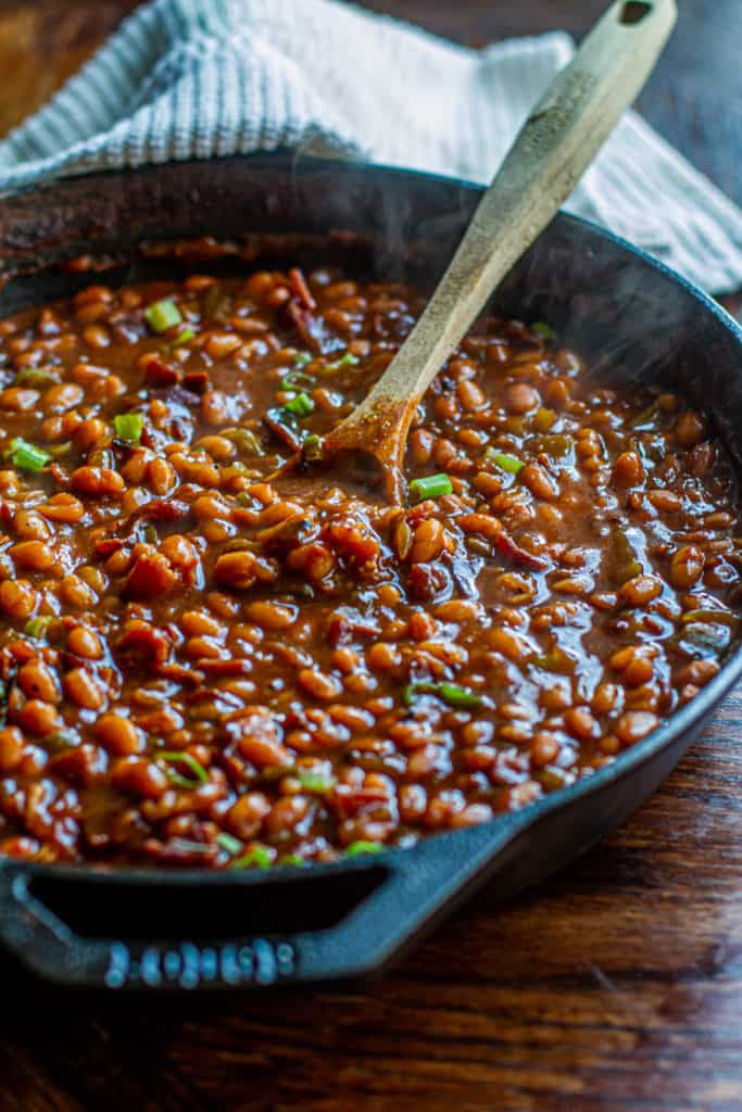 Cast Iron Brown Sugar Baked Beans with green onion sprinkled on top