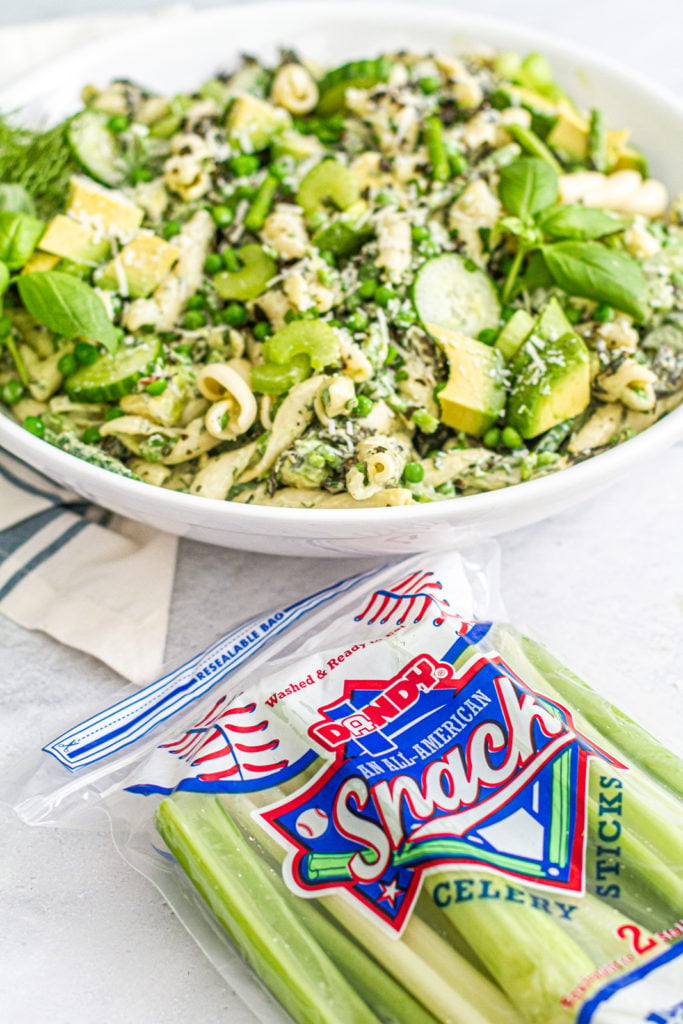 green goddess pasta salad in serving bowl beside dandy celery