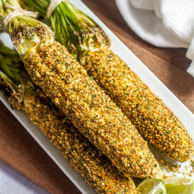 Elote, mexican street corn on a platter with limes