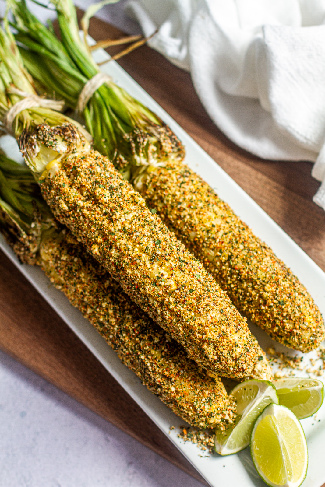 Elote, mexican street corn on a platter with limes
