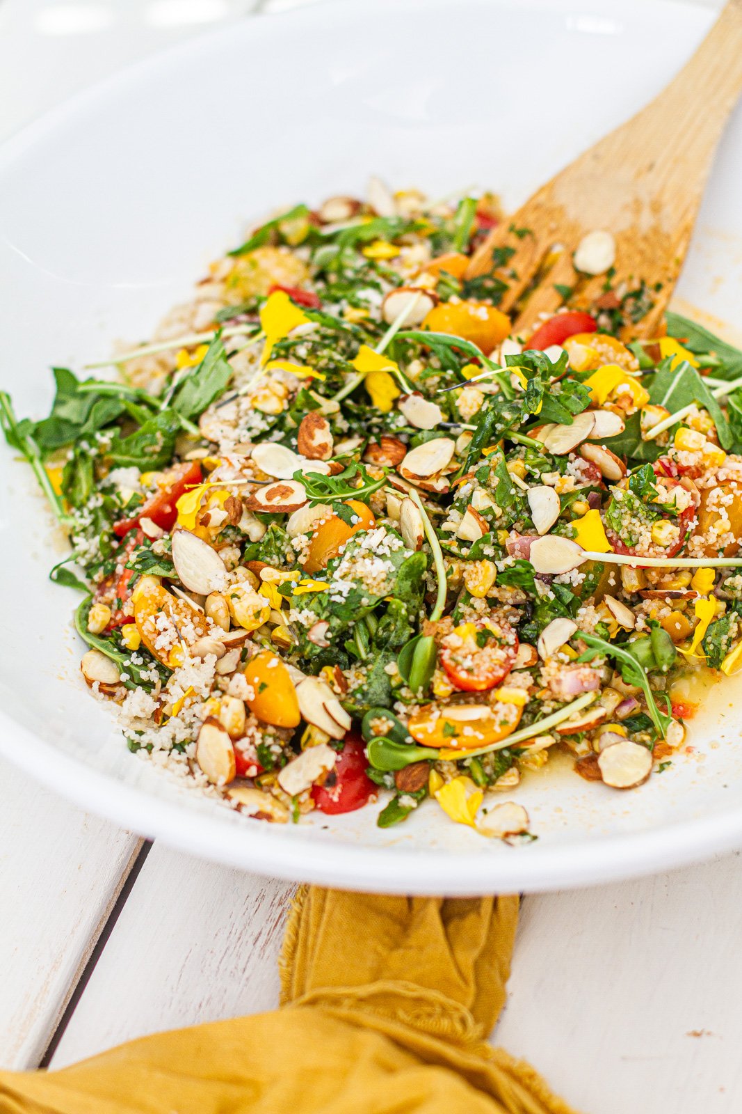 close up of white bowl with summer vegetable & fonio salad.