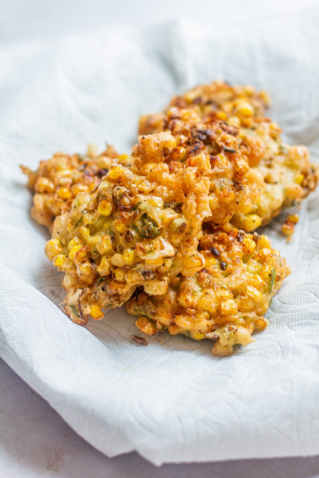 golden corn fritters on a paper towel lined dish