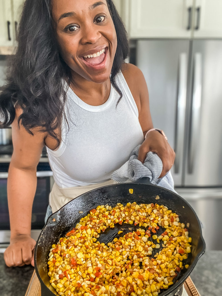 meiko temple holding skillet with fried corn