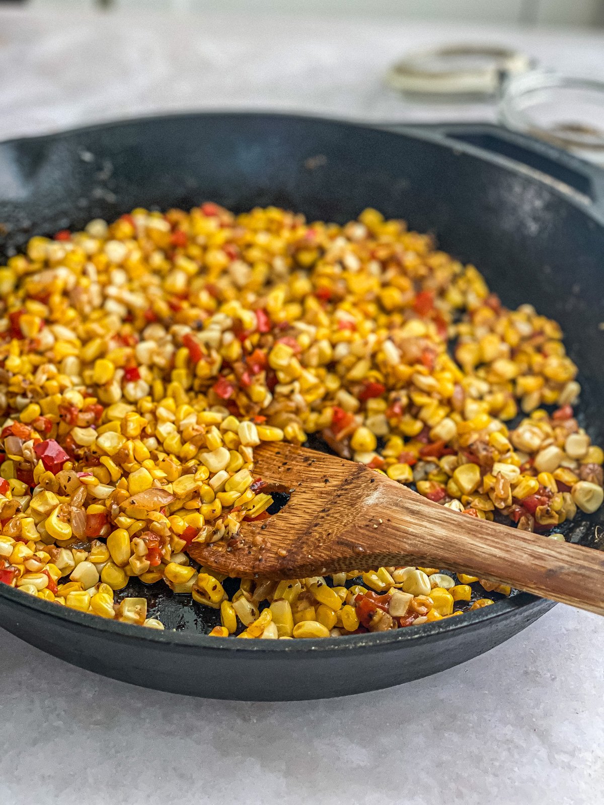 fried corn in skillet with black pepper on top