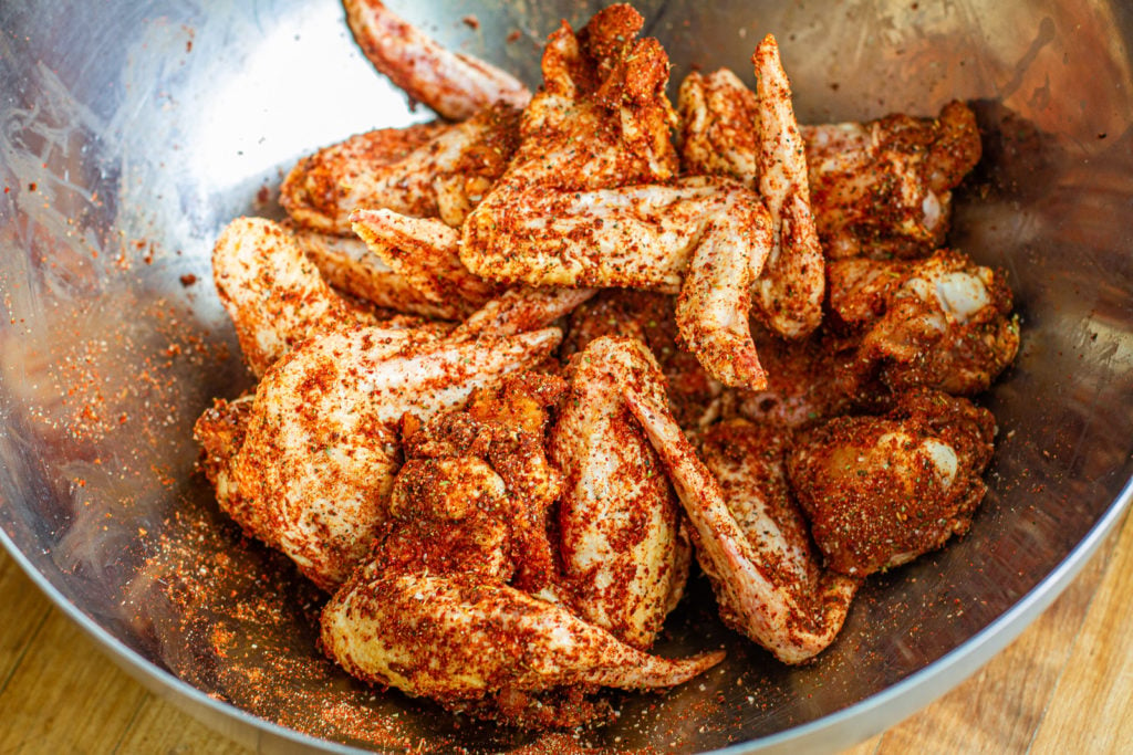 chicken wings coated in kansas city bbq rub in a large bowl