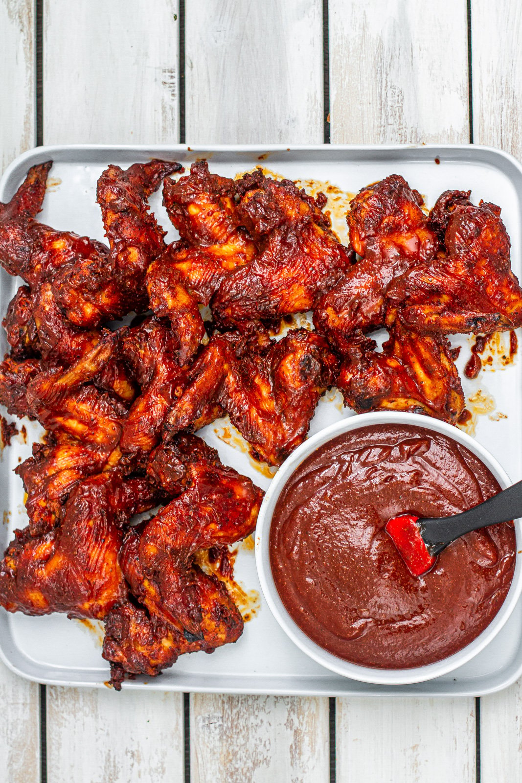 platter of kansas city bbq chicken wings with bbq sauce on the side