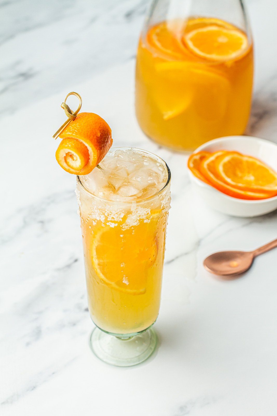 minneola paloma in glass with a spiral garnish peel