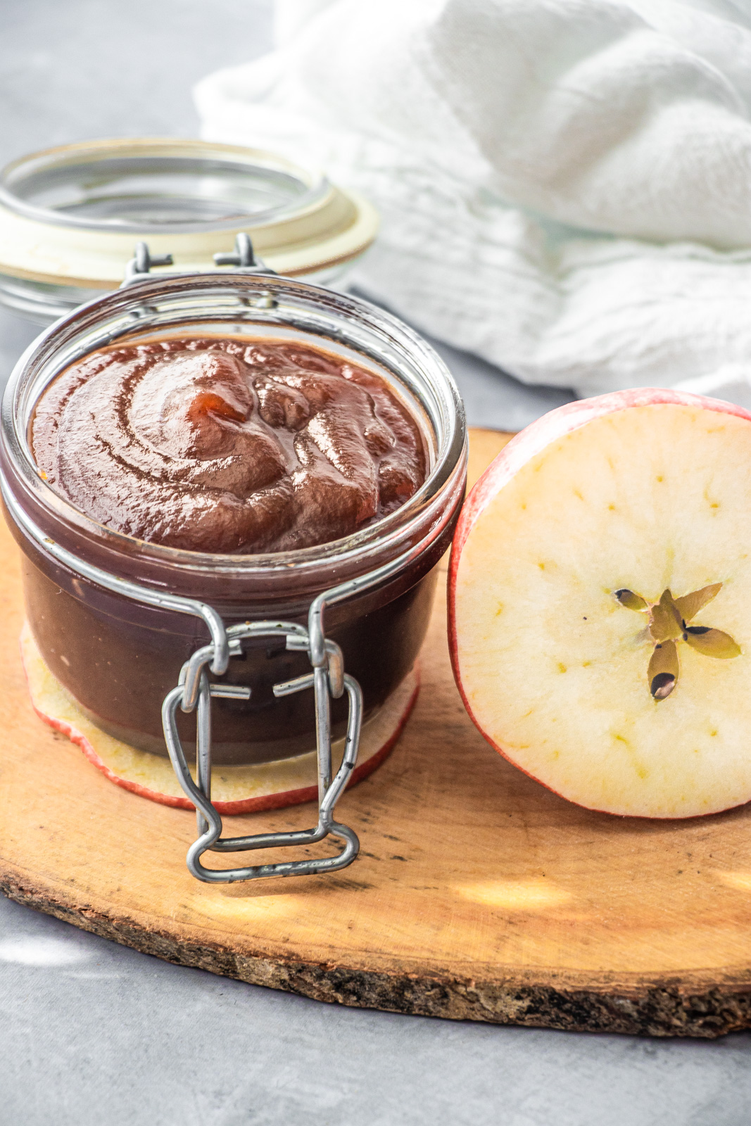 homemade apple butter in jar next to apple