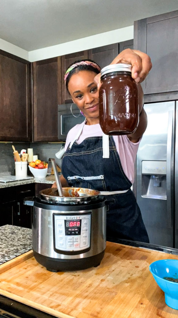 meiko temple holding jar of homemade apple butter from instant pot