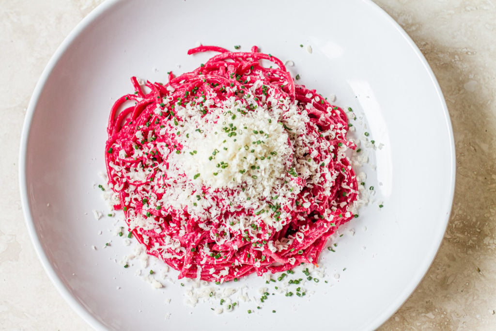 overhead of spaghetti with pink pasta sauce sprinkled with parmesan cheese