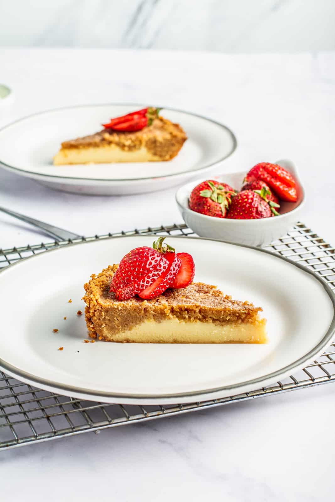 slice of goat milk pie on plate with strawberries
