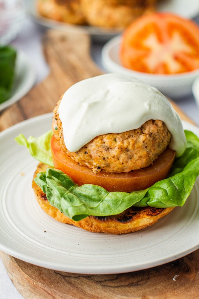 open face salmon burger with drizzle of whipped feta on the top