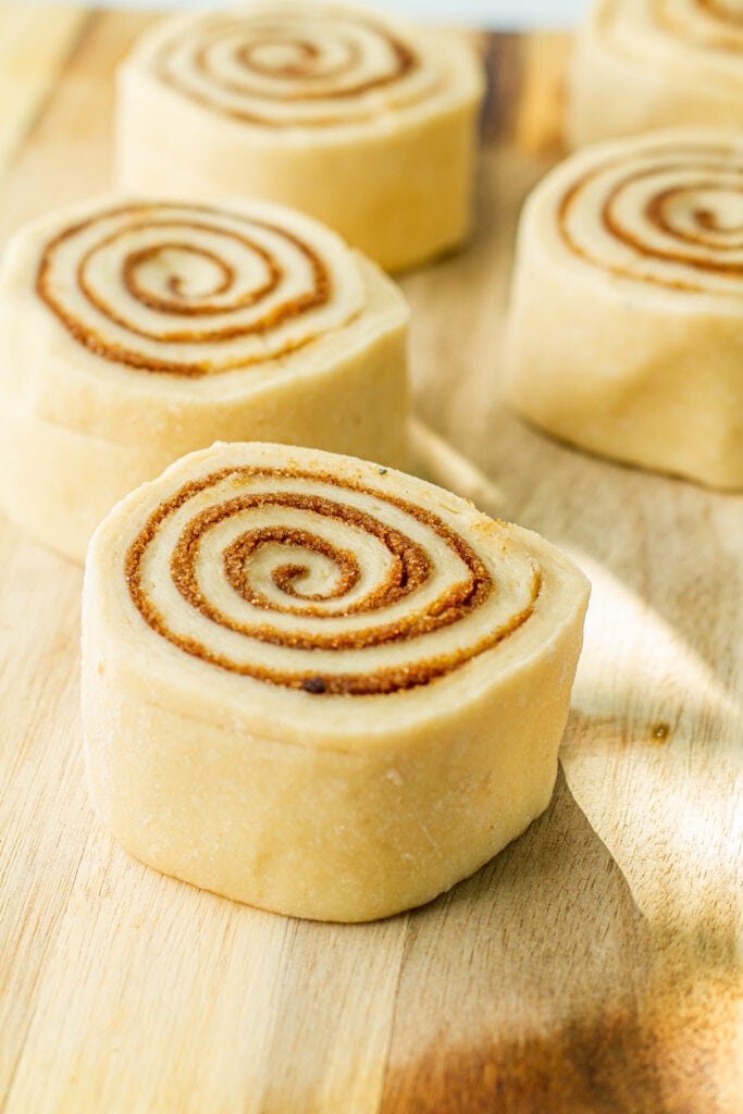 dough and cinnamon mix rolled up on cutting board