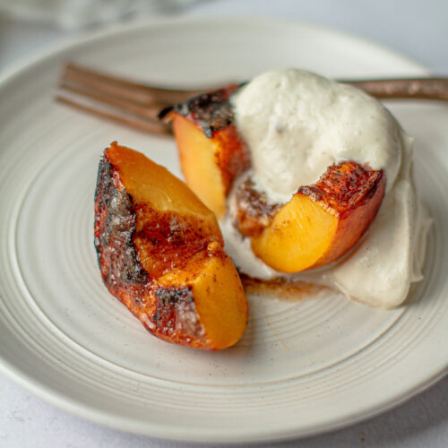 close up Brown Sugar Grilled Peaches with brown sugar whip on a plate with fork